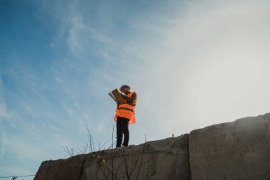 Mühendis, inşaatı yukarıdan izlemek için yüksek bir noktada yürüyor. .