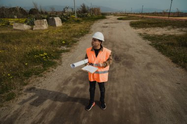 İnşaat sahasında elinde haritayla dolaşan bir mimar. . 