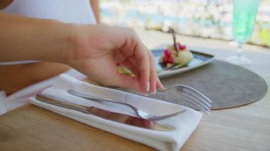 Gurme balık yemeğini yemek için çatal toplayan bir kadının eli. .