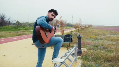 Adam denize bakan gitarı dinlenmek için çalar.. 