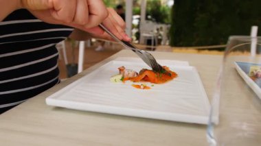 Kadın somon ve ahtapot tabağını ikiye bölüyor..