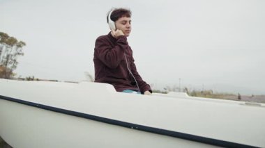 Adam kış boyunca sahilde bir teknenin içindeki müzikle dans ediyor. . 