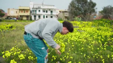 Anneler Günü Hediyesi için Sarı Çiçekleri Seçen ve Seçen Adam . 