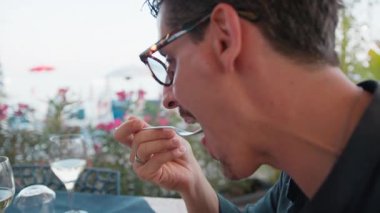 Sahilde öğle yemeği için bir ton balığının tadını çıkaran adam. .