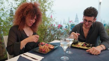 İki aşık öğle yemeği için sahilde spagetti yiyorlar. .