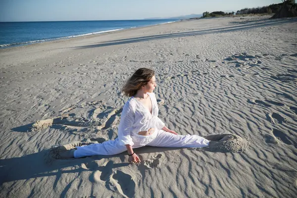 İtalyan Kız Beyaz Giysiler İçinde Okyanus 'un yanındaki yumuşak plajda Dans Ediyor .
