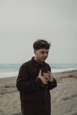 Hıristiyan adam sahildeyken İncil 'de dua okuyor. . 