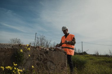 İnşaat alanına bakan ve not alan bir mühendis. . 