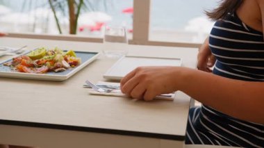 Balık yemek için çatal ve bıçak alan kadın. . 