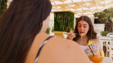 Güneşli bir İtalyan gününde spagetti yiyen genç bir kadın. . 