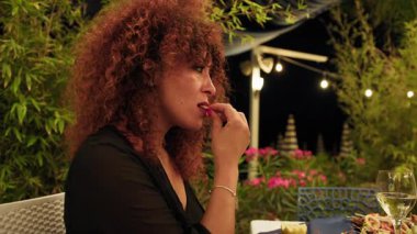 Açık hava lokantasında akşam yemeğinde balık yiyen bir kadın. . 