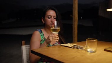 Otelde akşam yemeği sırasında şarap ve içki içen bir kadın. . 