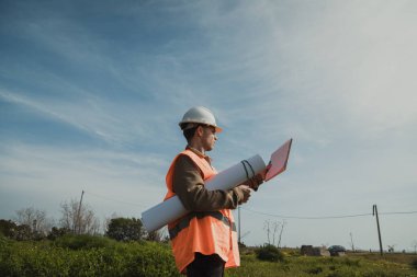 Mühendis, eski bina hakkında not almak için kalemi kullanıyor. . 
