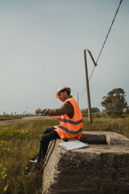 Bir kayanın üzerinde oturmuş not alan bir mühendis. . 