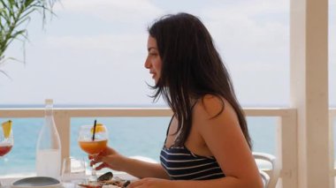 Yemek yerken Portakal Kokteyli İçen Kadın . 