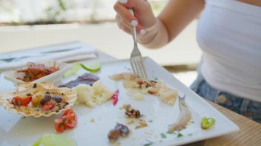 Güzel bir aperatifle öğle yemeğine başlayan bir kadın plaj otelinde yemek yiyor. . 
