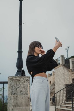 Gün boyunca şehir meydanında selfie çeken bir kadın. . 