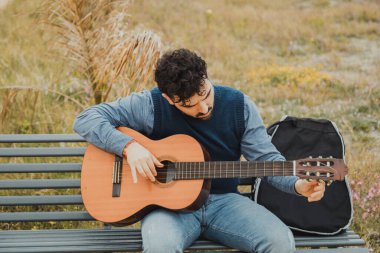 Gitarının müziğine dalmış bir adam. 
