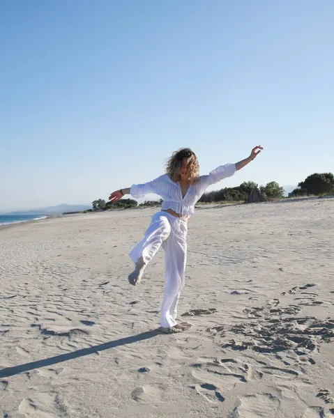 İtalyan Kız Beyaz Giysiler İçinde Okyanus 'un yanındaki yumuşak plajda Dans Ediyor .