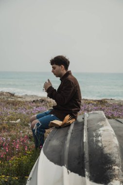 Hıristiyan adam sahildeyken İncil 'de dua okuyor. . 