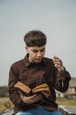 Hıristiyan adam sahildeyken İncil 'de dua okuyor. . 