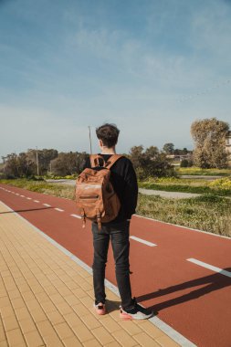 İşten sonra gelen adam dışarıda otobüs beklemekten yoruldu. . 