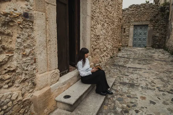 Kilisenin girişinde İncil okuyan dindar genç bir kadın. . 