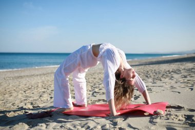 Genç kadın sahilde ters köprü spor salonuna hazırlanıyor. .