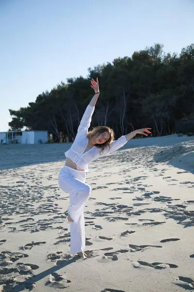 İtalyan Kız Beyaz Giysiler İçinde Okyanus 'un yanındaki yumuşak plajda Dans Ediyor .