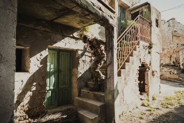 Genç asker dikkatle yıkılmış bir evin merdivenlerinden aşağı iniyor.. 