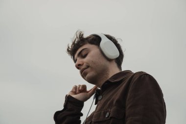 Kışın kıyıda müzik dinleyen bir adam..