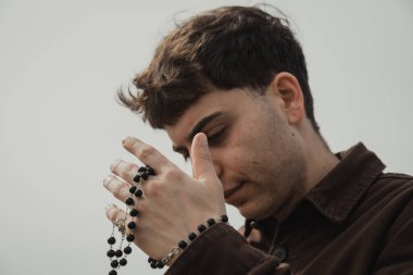 Adam kışın kıyıda tespih ve gözleriyle dua ediyor. . 