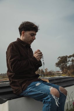 Hıristiyan adam sahildeyken İncil 'de dua okuyor. . 