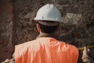 Mühendis, eski bina hakkında not almak için kalemi kullanıyor. . 