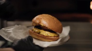 Şef fırının içine gurme burger koyuyor. . 