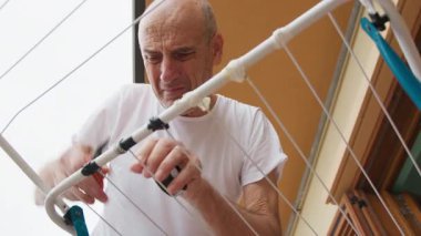 Adam çamaşır ipini koli bandı ve klip ile onarıyor.. 