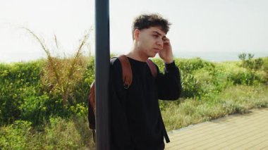 İşten sonra gelen adam dışarıda otobüs beklemekten yoruldu. . 