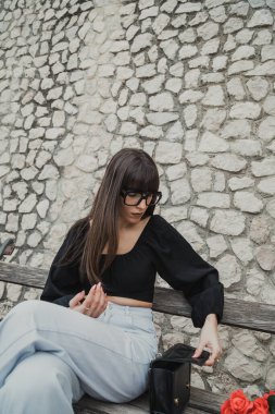 Kadınlar bankta oturan siyah çantada arama yapıyorlar..