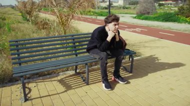 Gün boyunca parktaki bankta kızgın ve stresli bir adam. . 