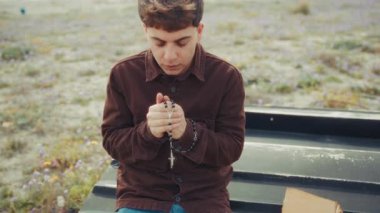 Sahildeki Hristiyan bir adam için yoğun bir dua anı. 