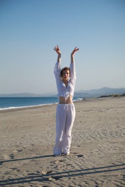 İtalyan Kız Beyaz Giysiler İçinde Okyanus 'un yanındaki yumuşak plajda Dans Ediyor .