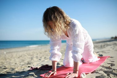 Kumsalda, bir kızın denizinin yanında egzersiz yapıyorum. .