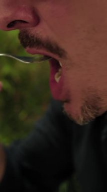 Yemek sırasında çatallı pizzadan Mozzarella yiyen adam. . 