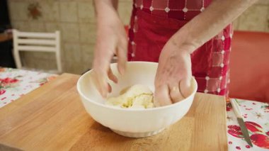 Man, un ve hamur karıştırmak için kaseye su döker.. 