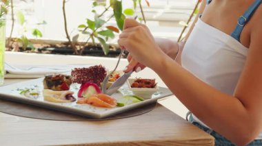 Genç Kadın Yazın Plaj Yakınındaki Restoran Tabağından Çiğ Somon Kesiyor.