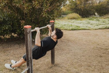 Adam, formda kalmak için parktaki demir çubukta egzersiz yapıyor.. 
