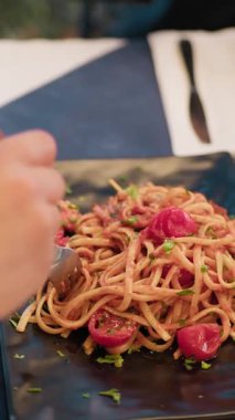 Istakoz ve domates soslu spagetti yemek için çatal kullanan kadın. .