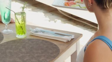 Garson güzel bir restoranın masasına bir tabak balık aperatifi getirir..