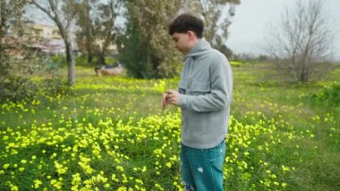 Mutlu adam hediye için topraktan çiçekleri seçiyor. . 