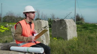 Doğadaki Mimar Proje hakkında notlar alırken Oturuyor. 